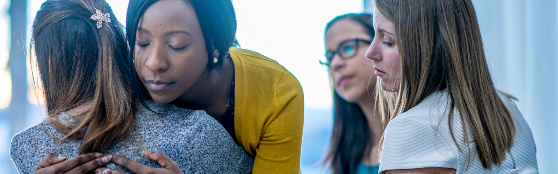 Women supporting each other in group therapy for addiction treatment.
